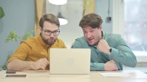Men Collaborate at Computer and Celebrate Achievement