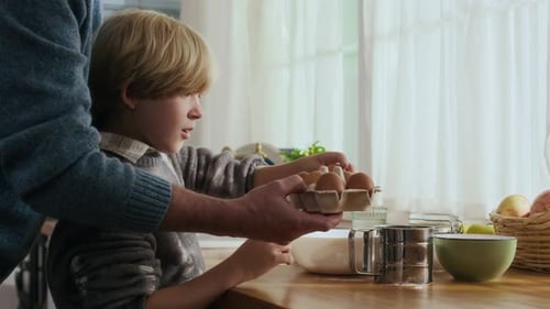 Child and Adult Baking Together in Bright Kitchen