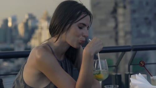 Pensive woman sitting at a rooftop cafe