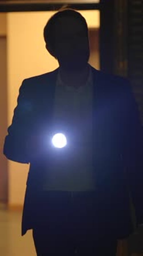 Auburn-Haired Man Examines Papers in Dimly Lit Building
