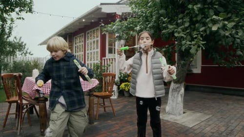 Children Blowing Bubbles in Backyard with Grandfather