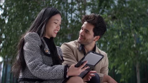 Man and Woman Talking and Looking at Tablet