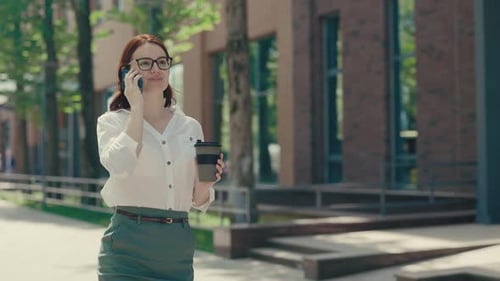 Ginger Business Woman in Braces Wearing Glasses in Formal Suit Going Near the Business Centre