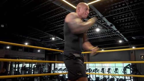 Focused African Male Boxer Shadow Boxing in a Vibrant Gym