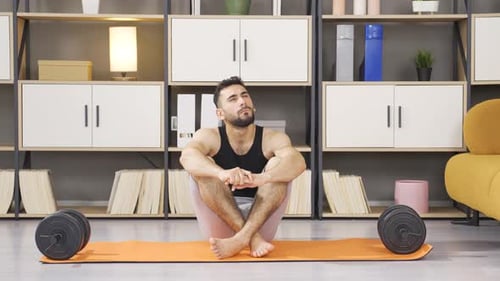 Man Sitting on Exercise Mat with Weights