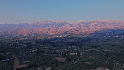 Expansive view of rolling hills and mountains at sunset in Greece