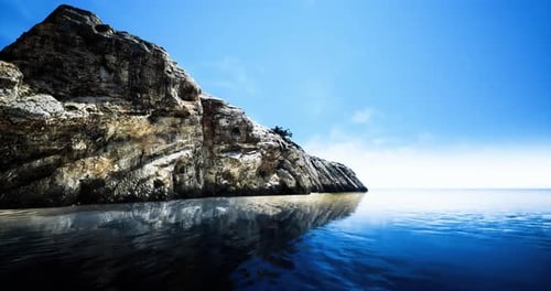 Serene Coastal View with a Rocky Cliff and Tranquil Waters at Sunrise