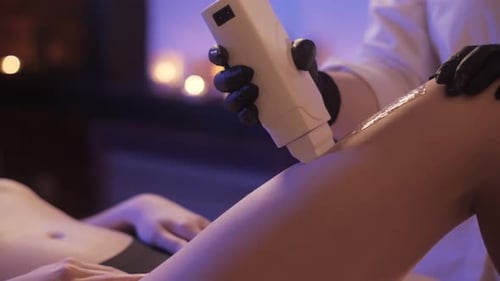 Depilation Master entfernt Haare aus dem Bein eines schönen jungen Mädchens