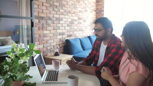 Couple Video Calling on Laptop Computer At Home