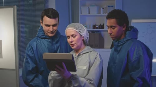 Scientists Inspecting Tablet in Lab Research Facility