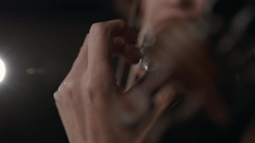 Close Up of Woman Playing Violin in Dark Room