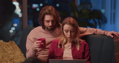 Couple Relaxing at Home With Laptop