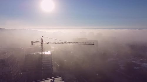 Tower Cranes on a Construcion Site with Dense Fog Aerial View