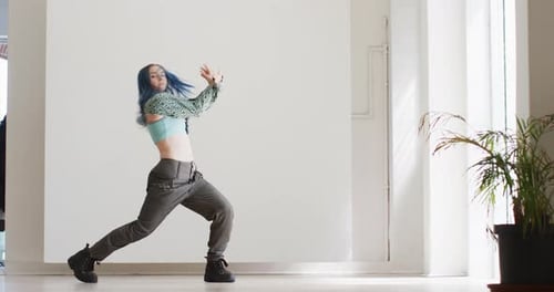 Portrait of caucasian female dancer dancing alone in dance studio, slow motion