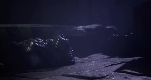 Dark Alley Filled with Trash Bags and Dim Lighting at Night