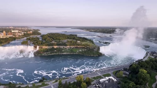 Wide Aerial View of American and Canadian Niagara Falls at Sunset with Vibrant Sky and River, Canada