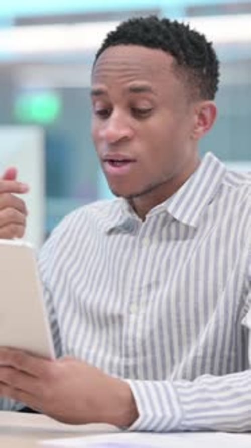 African Businessman making Video Call on Tablet in Office, vertical video