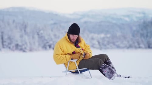 Man Sitting On A Frozen Lake For Fishing - Ice Fishing In Indre Fosen, Norway - wide