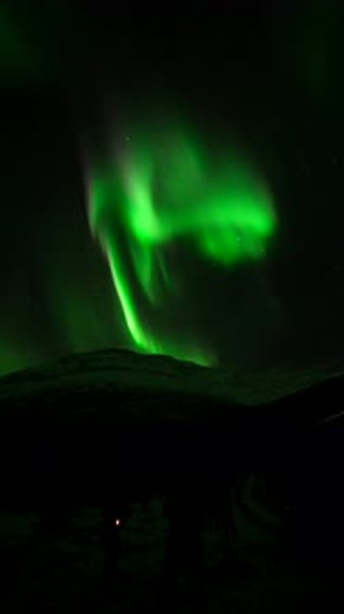 Vertical Real Time Northern Lights Over Mountains In Tromso, Norway