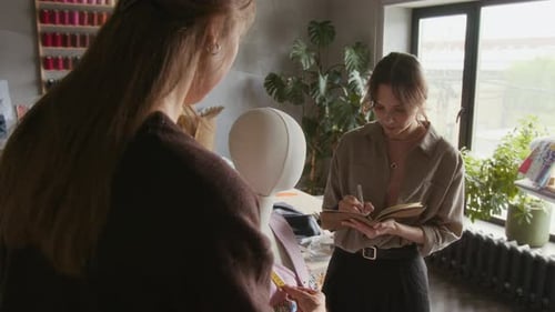 Female Fashion Designers Measuring of Garment on Mannequin in Studio