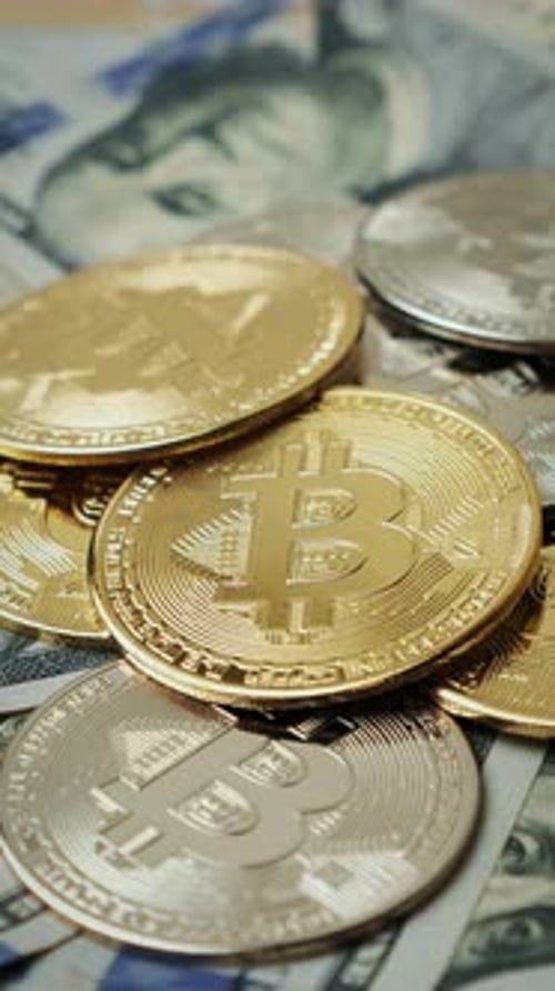 Close Up of Bitcoin Coins on Dollar Bills
