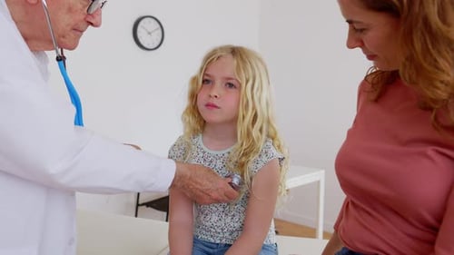 Doctor Examining Child with Stethoscope in Office