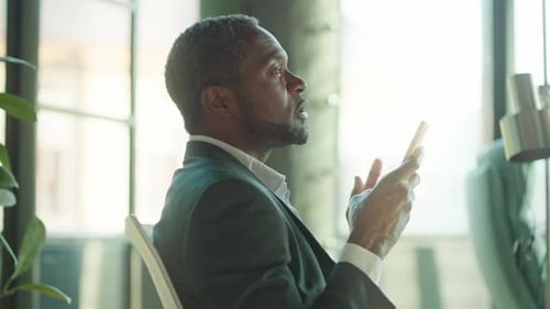 Man in Suit Talking on Mobile Phone Indoors