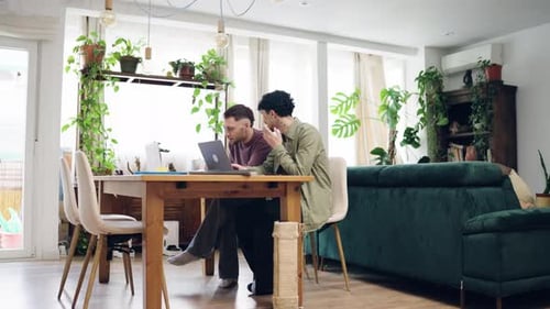 Two Men Working Together on Laptop in Home