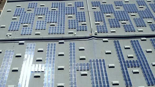 Photovoltaic solar panels on commercial building roof, renewable energy concept, Aerial topdown side