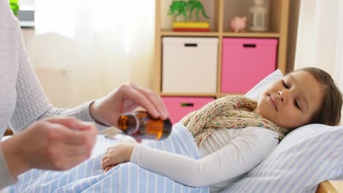 Loving Mother Caring for Sick Child with Medicine