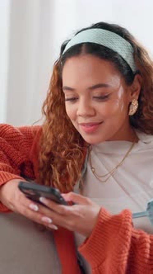 Smiling Woman Uses Phone Indoors During Daytime
