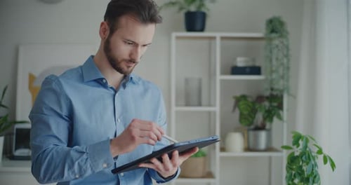 Young Adult Using Tablet With Stylus Pen at Home