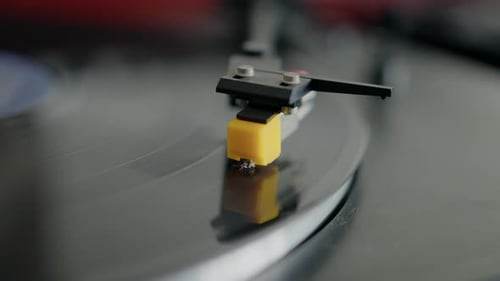Close-up of a record player needle on a spinning vinyl record, highlighting the vintage audio setup.