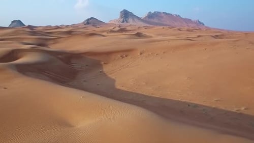Golden Hour Drone View of an Isolated Desert with Towering Dunes and Peaks