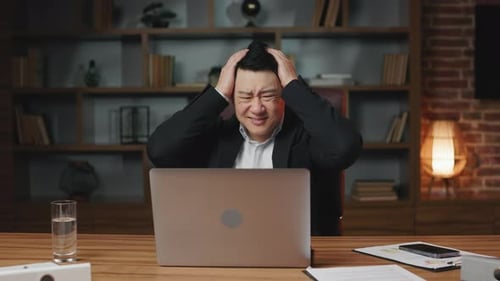 Frustrated Adult in Office Gesturing at Laptop