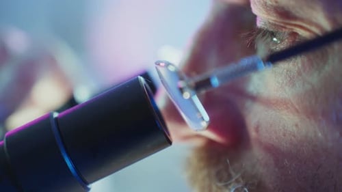 Mature Adult Using Microscope in Bright Lab