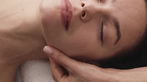 Woman Receiving Relaxing Facial Massage at Spa