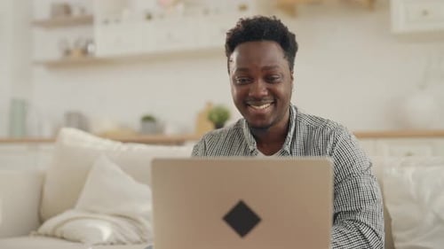 Young Adult Using Laptop Computer in Home