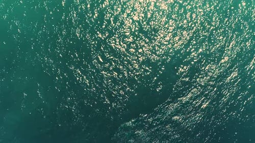Aerial on moving slow motion Clear water Sea Ocean With Small ripples, sun reflection and caustic wa