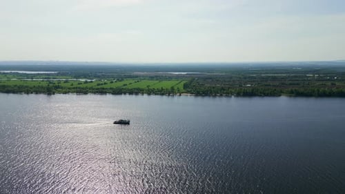 Cargo Ship Navigating on a Wide River on a Sunny Day Clip