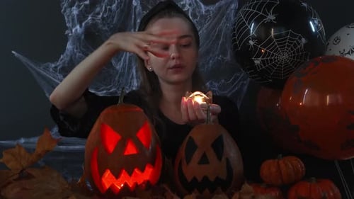 Young Woman with Halloween Pumpkins and Balloons
