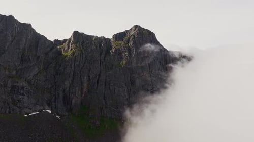 Cloudscape Exploration Drone's Journey to Mountain Peak on Clear Day