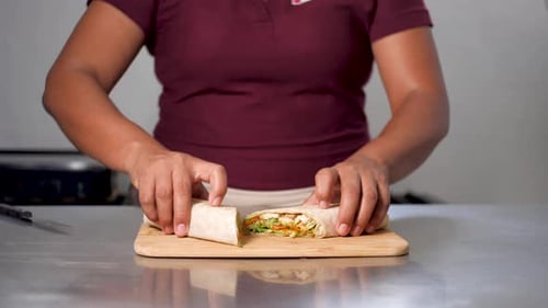 Slowmotion Of Latin American Chef präsentiert mexikanisches Gourmet-Burrito mit Hühnchen, Gemüse und Chipotle-Burrito