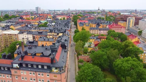 Colorful architecture building with a black roof, road passing in front and cityscape in background,