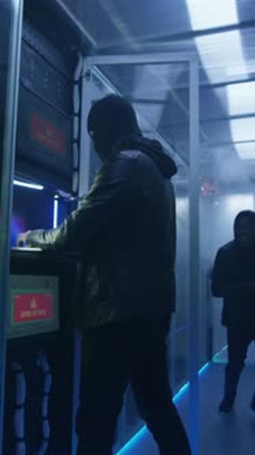 Deux pirates informatiques terminent un piratage et s'échappent d'une pièce enfumée