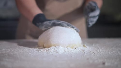 Person Kneading Dough on a Flour Covered Surface