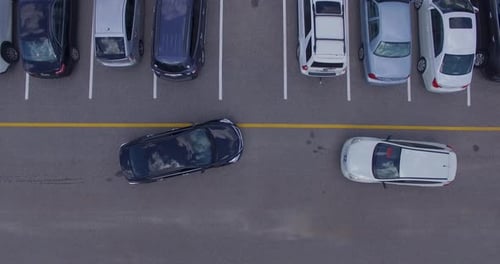 Zwei Autos versuchen, auf denselben Parkplatz zu gelangen, 4K-Drohne direkt über ihnen.