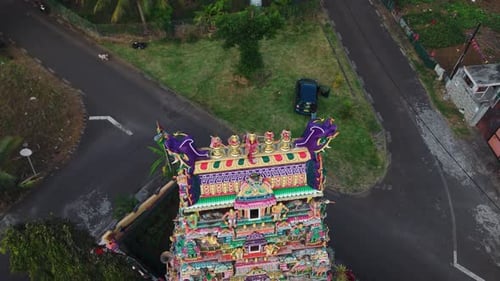Sommet aérien d'un complexe de temples tamouls entouré d'arbres présentant des motifs de toit colorés