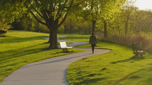Mujer caminando por el parque disfrutando de un momento de relajación en un parque público Vista amplia