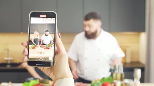 Une jeune femme et un homme préparent à manger et animent une émission de cuisine que les blogueurs diffusent depuis Kitchen Healthy